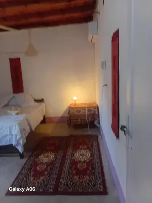 a bedroom with a bed and a table with a rug at Mountain guest house in Luxor