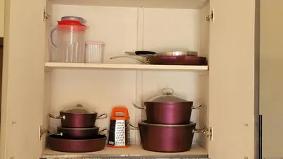 a cupboard with pots and pans in a kitchen at Casablanca star hurghada in Hurghada