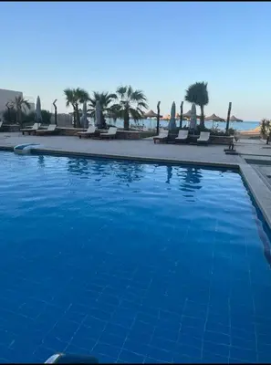 a large blue swimming pool next to a beach at Casablanca star hurghada in Hurghada
