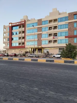 a large building with cars parked in a parking lot at Casablanca star hurghada in Hurghada