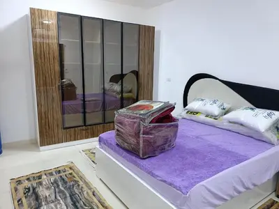 a room with a bed with purple sheets and a mirror at شقة كاملة بغرفتي نوم دور ارضي in Hurghada