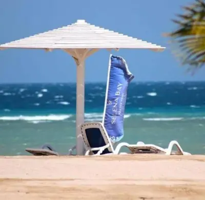 a pair of chairs and an umbrella on the beach at Selena Bay in Hurghada