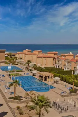 a resort with a large swimming pool next to the ocean at Selena Bay in Hurghada