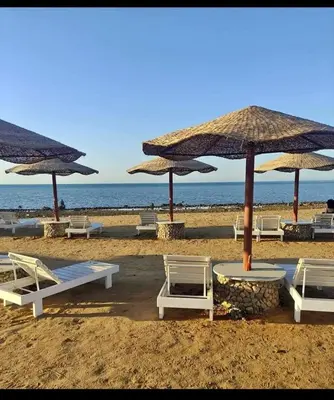 a beach with chairs and umbrellas on the beach at شقه على البحر مباشره in Hurghada