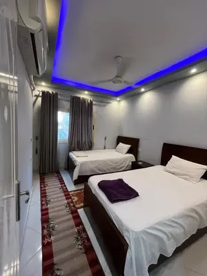 two beds in a room with a blue ceiling at Roma Apartment LXR in Luxor
