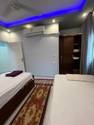 a bedroom with two beds and a blue ceiling at Roma Apartment LXR in Luxor