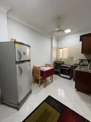a kitchen with a stainless steel refrigerator and a table at Roma Apartment LXR in Luxor