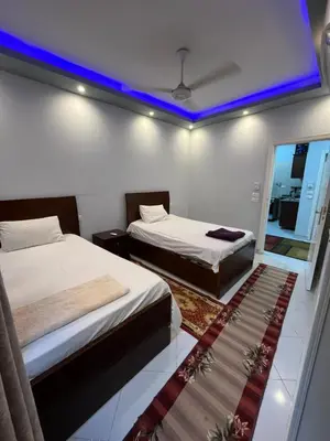 two beds in a room with a blue ceiling at Roma Apartment LXR in Luxor