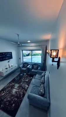 a living room with a couch and a large window at Al Mansi Luxury Retreat in Jazīrat al ‘Awwāmīyah