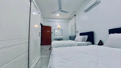 a bedroom with two beds and a mirror at Al Mansi Luxury Retreat in Jazīrat al ‘Awwāmīyah