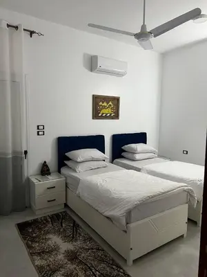 a bedroom with two beds and a ceiling fan at Al Mansi Luxury Retreat 1 in Luxor