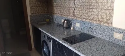 a kitchen with a sink and a washing machine at جولدن طيبه الذهبيه in Hurghada