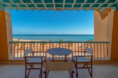 a table and chairs on a balcony with a view of the beach at Luxury Stays in New Marina El Gouna in Hurghada