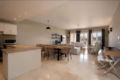 a kitchen and living room with a table and chairs at Luxury Stays in New Marina El Gouna in Hurghada