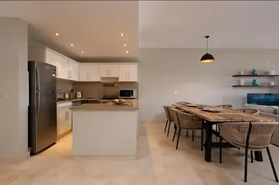 a kitchen and dining room with a table and a refrigerator at Luxury Stays in New Marina El Gouna in Hurghada