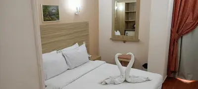 a bedroom with a white bed with a mirror at S S Luxor Hotel in Luxor