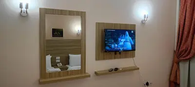 a bathroom with a mirror and a tv on the wall at S S Luxor Hotel in Luxor