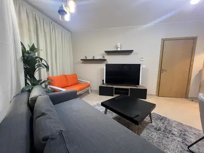 a living room with a couch and a flat screen tv at Beachside Mangroovy 1BR in Hurghada