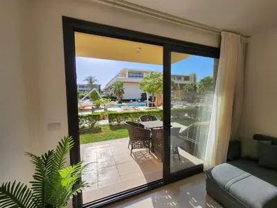a living room with a sliding glass door to a patio at El Gouna Poolfront Cozy Stay 2BR in Hurghada