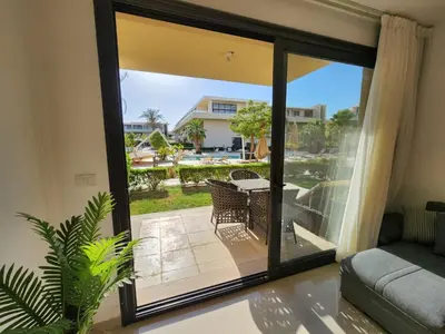 a living room with a sliding glass door to a patio at El Gouna Poolfront Cozy Stay 2BR in Hurghada