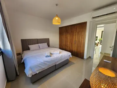 a bedroom with a bed with two towels on it at El Gouna Poolfront Cozy Stay 2BR in Hurghada