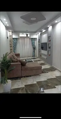 a living room with a couch and a tv at Dream Apartment 4 in Hurghada