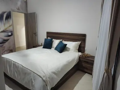 a bedroom with a large white bed with blue pillows at Apartmant for family in Hurghada in Hurghada