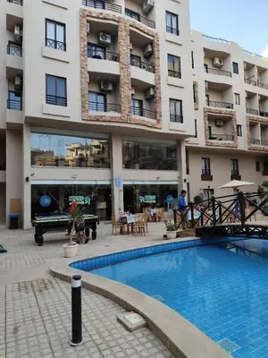 a hotel with a swimming pool in front of a building at Apartmant for family in Hurghada in Hurghada