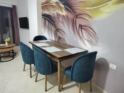 a dining room with a table and blue chairs at Apartmant for family in Hurghada in Hurghada