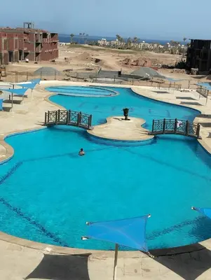 a group of three pools with blue water at Panorama View Sahl Hashesh Luxury Suite in Hurghada