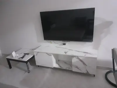 a living room with a tv on a white wall at Panorama View Sahl Hashesh Luxury Suite in Hurghada
