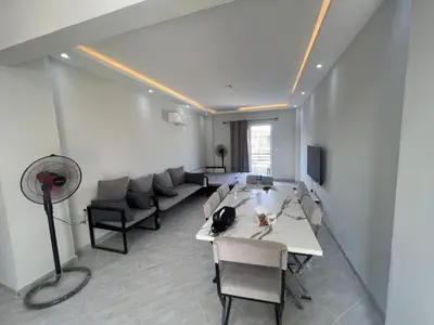 a room with a table and chairs and a fan at Panorama View Sahl Hashesh Luxury Suite in Hurghada