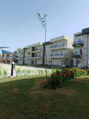 a large apartment building with flowers in a yard at Panorama View Sahl Hashesh Luxury Suite in Hurghada