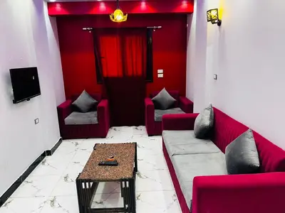 a living room with red furniture and a table at شقه في ميدان العروسه in Hurghada