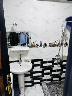 a white bathroom with a sink and a mirror at شقه في ميدان العروسه in Hurghada