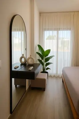 a bedroom with a mirror and a table with a plant at Sunny Escape 1BR with Pool Access in Hurghada