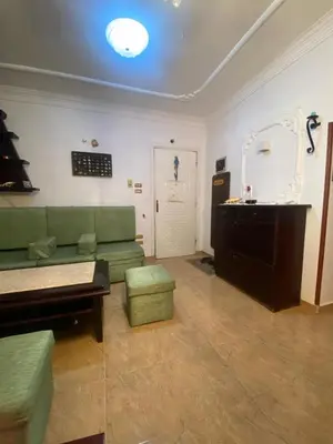 a living room with a green couch and a table at Jana in Hurghada
