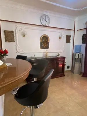 a dining room with a table and a clock on the wall at Jana in Hurghada