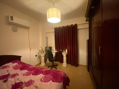 a bedroom with a bed and a desk with a chair at Jana in Hurghada