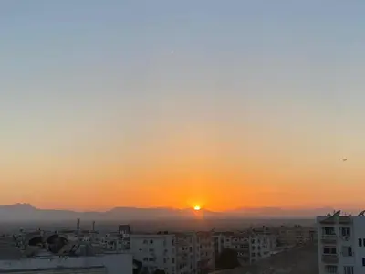 a sunset over a city with buildings in the foreground at Jana in Hurghada