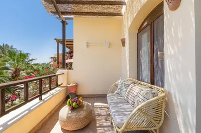 a balcony with a wicker bench and a window at Peaceful Oasis, Stunning Views and Refreshing Pool, El Gouna in Hurghada