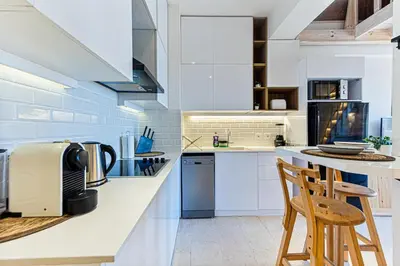 a kitchen with white cabinets and a counter with stools at Peaceful Oasis, Stunning Views and Refreshing Pool, El Gouna in Hurghada