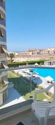 a white chair on a balcony with a swimming pool at Scandic resort in Hurghada