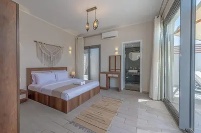 a bedroom with a bed and a large window at Lovely 2BR with Private Pool in Bali El Gouna in Hurghada