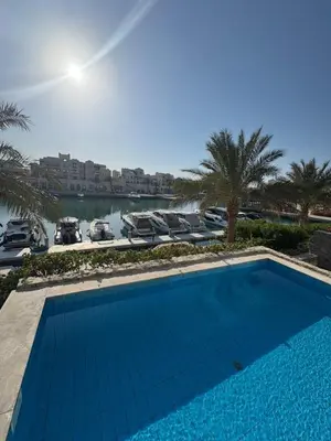 a large blue swimming pool next to a marina at Fanadir Marina 3bedroom private pool in Hurghada