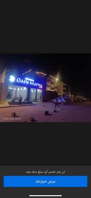 a person walking in front of a store at night at Oasis marina in Hurghada