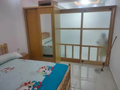 a bedroom with a bed and a large glass door at كمبوند كابتن in Hurghada