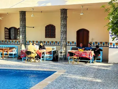 a group of people sitting at tables next to a pool at Luxor Hotel in Luxor