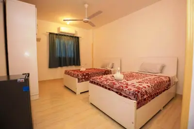 a bedroom with two beds and a ceiling fan at Luxor Hotel in Luxor