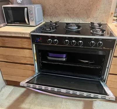 a stove in a kitchen next to a microwave at El Gouna Nubian Lagoonfront Villa - 4BR, 9 Guests in El Gouna